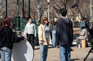 The two actors talking through the scene, a round reflector angled in from the left and the boom overhead
