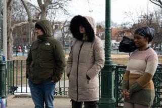 Three of the background cast standing along the bandstand railing between takes