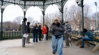 The assistant director walking back through the bandstand mid-sentence, the company standing by with their pages
