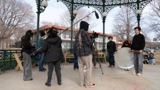 The unit shooting at the bandstand, boom overhead and the round reflector angled in from the right
