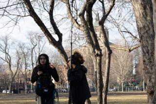 The sound recordist with her mixer bag and the boom operator working between the bare trees