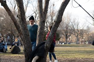 Two of the company waiting behind a forked tree with a coat slung over the branch, the boom just in frame