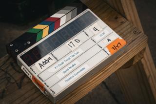 The clapperboard face up on a weathered wooden ledge, marked 17D for If I Could Touch the Sun