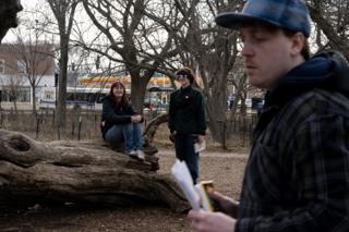 Two of the cast waiting on the log, the assistant director going through the pages in the foreground