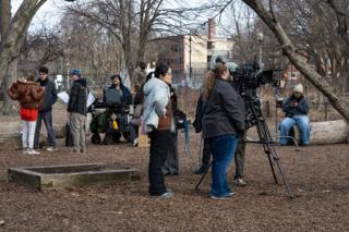 The unit spread out across the wooded lot, camera on sticks and the monitor cart parked among the logs