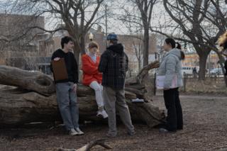 The director and script supervisor going over the next setup with two of the cast at the fallen log