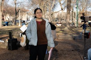 Crew member standing by the camera with the day's pages under her arm