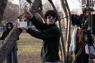 Second assistant camera holding the clapperboard up to the lens for the next take