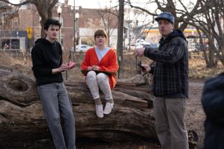 The director pointing off to set the eyeline, phone in hand, the cast holding their places