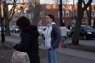 Two crew talking at the kerb, the folded reflector tucked under one arm