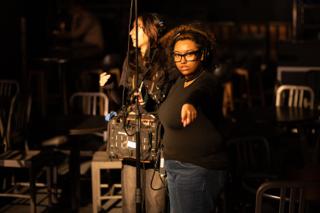 Sound and camera crew tracking a take from behind the rig, one pointing out a mark