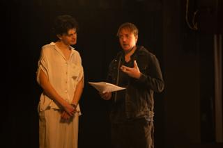 Director talking an actor through the next take at the microphone, script pages in hand