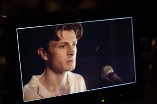 Camera monitor showing a close-up of the actor beside a microphone