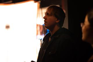 Crew member looking up, lit from the side by a large softbox