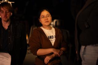Crew member with folded arms standing among the team between takes