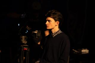Actor in profile beside the camera, waiting for the take