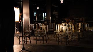 Empty chairs arranged across the floor of the venue before the crowd arrives