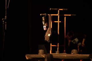 Equipment cart and a microphone stand standing in a pool of light on the empty stage