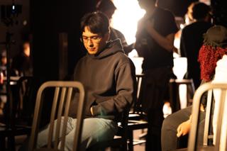 Crew member sitting among the chairs, waiting between setups